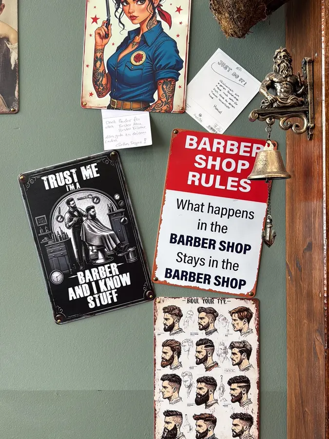 Blechschilder an der grünen Wand, darunter „Barber Shop Rules“