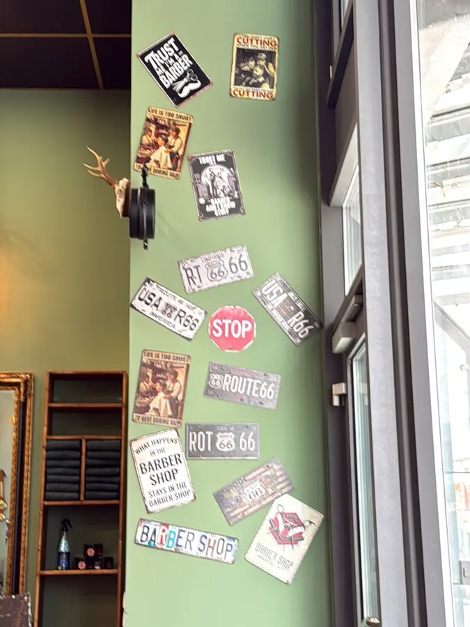 Wand mit Route-66-Nummernschildern und Barber-Schildern